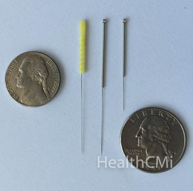 Filiform needles with coins for size comparison. 