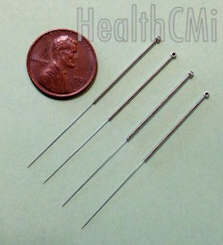 Four needles and a penny compared. 