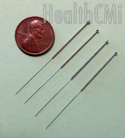 Four needles and a penny compared. 