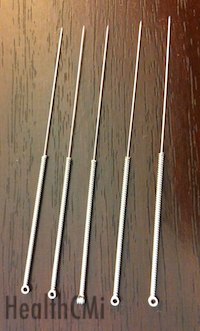 The image contains five 32 gauge acupuncture needles made of stainless steel.